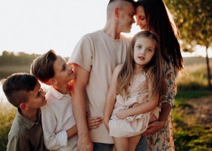 Family enjoying quality time together outdoors by the lake during sunset.